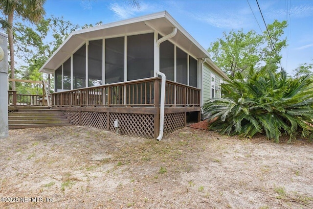 1418 Palm St NE, Steinhatchee, FL 32359 - back of property featuring a sunroom and a wooden deck