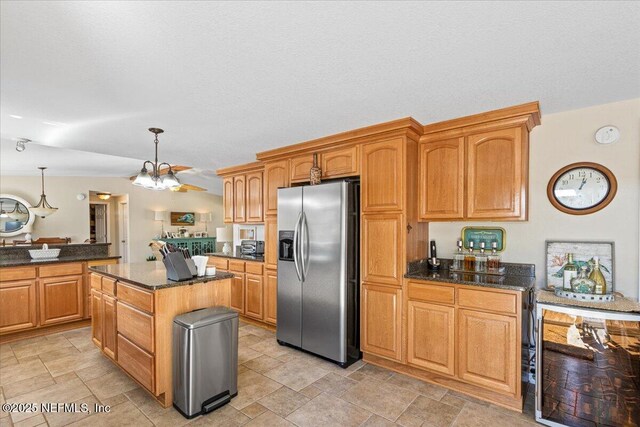 1418 Palm St NE, Steinhatchee, FL 32359 - kitchen with stainless steel fridge, dark stone counters, a chandelier, pendant lighting, and stone finish flooring