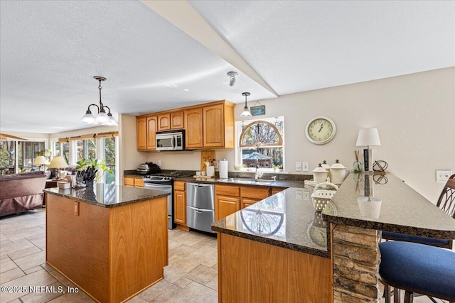 1418 Palm St NE, Steinhatchee, FL 32359 - kitchen with stainless steel appliances, a peninsula, a sink, and plenty of natural light