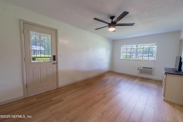 1525 E Call St, Starke, FL 32091 - unfurnished living room with a ceiling fan, light wood-style floors, a wall mounted air conditioner, and baseboards