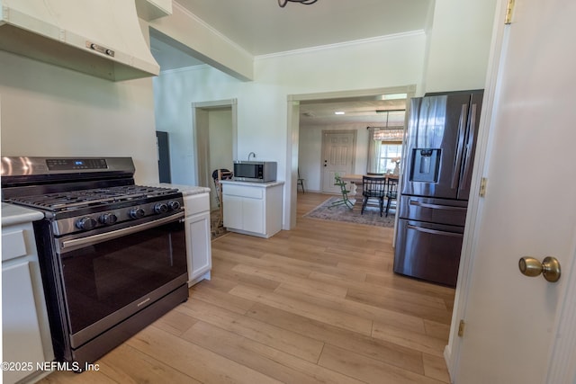 1525 E Call St, Starke, FL 32091 - kitchen with appliances with stainless steel finishes, under cabinet range hood, white cabinetry, light wood-style flooring, and light countertops