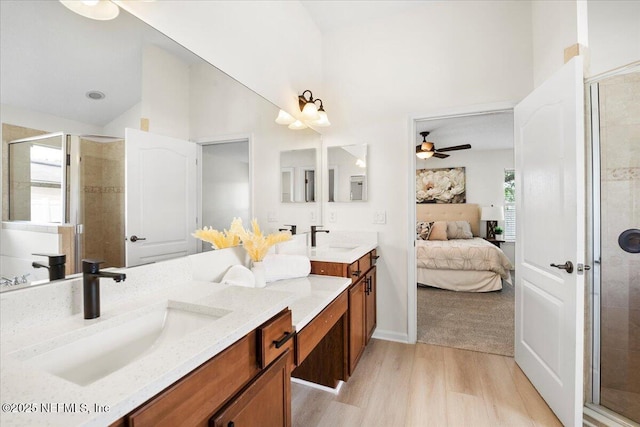 full bath with a ceiling fan, ensuite bathroom, a shower stall, wood finished floors, and high vaulted ceiling
