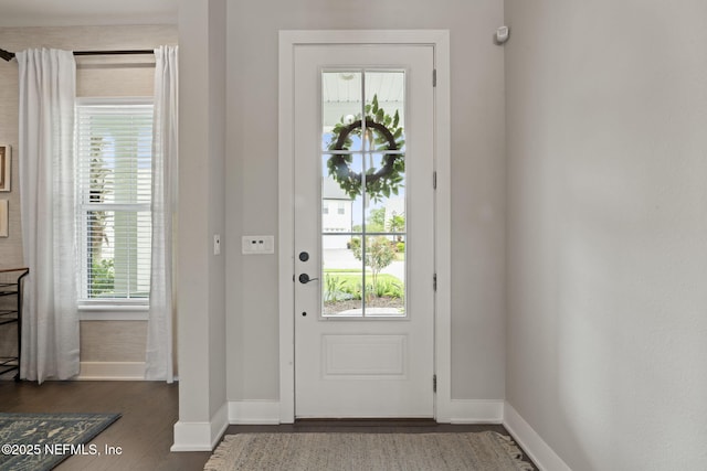doorway with baseboards and dark wood finished floors