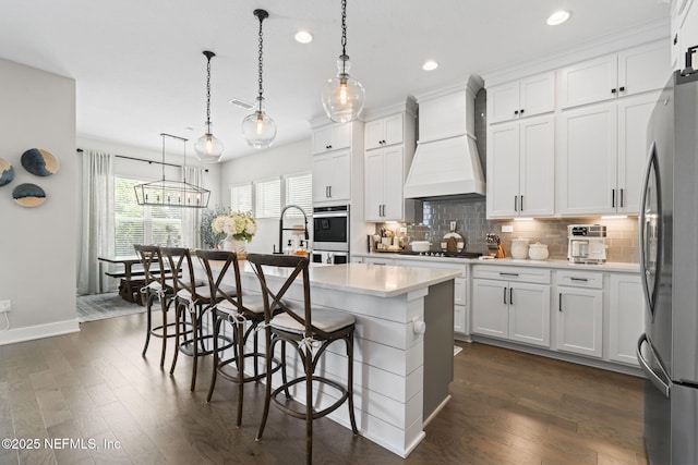kitchen featuring premium range hood, recessed lighting, dark wood-style flooring, decorative backsplash, and light countertops