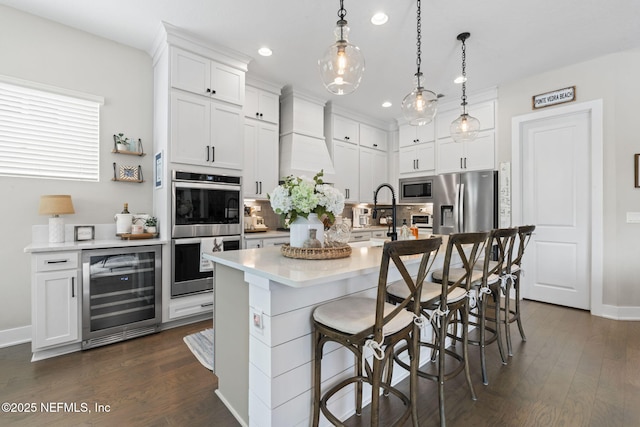 kitchen featuring beverage cooler, appliances with stainless steel finishes, a sink, recessed lighting, and light countertops
