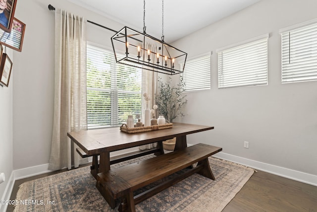 dining room featuring a chandelier, healthy amount of natural light, and baseboards