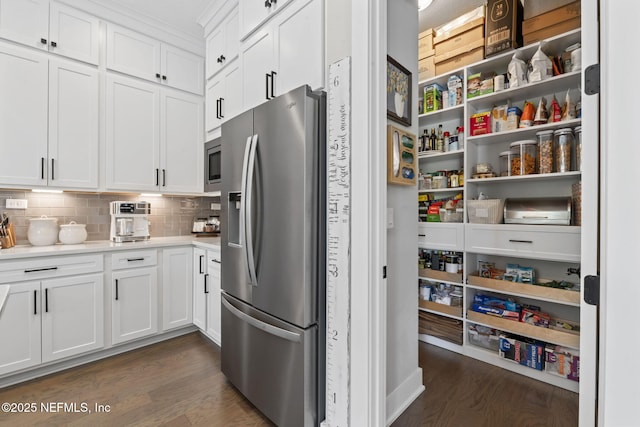 kitchen with appliances with stainless steel finishes, dark wood-style floors, white cabinetry, backsplash, and light countertops