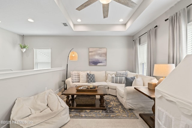 living room with ceiling fan, recessed lighting, and a raised ceiling