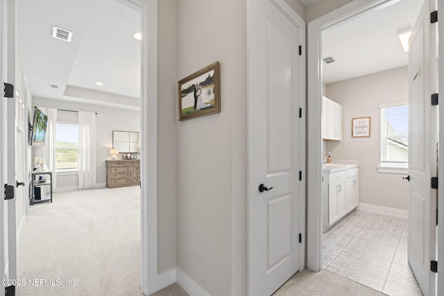corridor featuring baseboards, light colored carpet, and recessed lighting