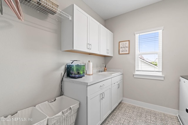 laundry room with a sink and baseboards