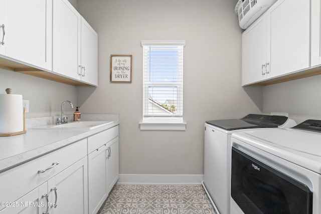 laundry area with washing machine and clothes dryer, baseboards, and cabinet space