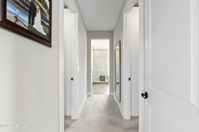 hall featuring carpet floors and baseboards