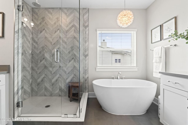 full bathroom with a stall shower, a soaking tub, vanity, tile patterned flooring, and baseboards
