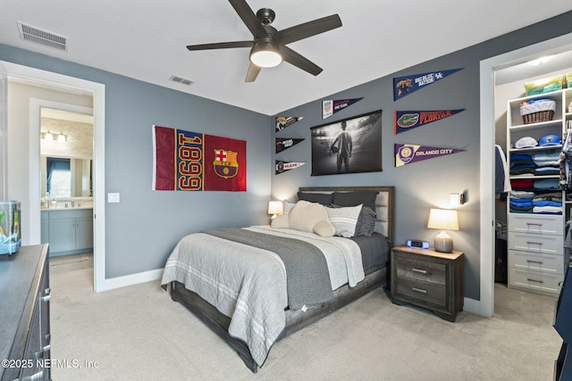 bedroom with light colored carpet, a spacious closet, baseboards, and a closet