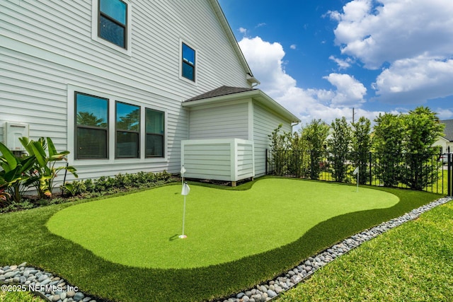 view of yard with a putting green and fence