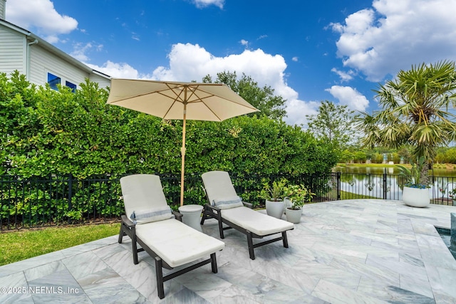 view of patio / terrace with fence and a water view