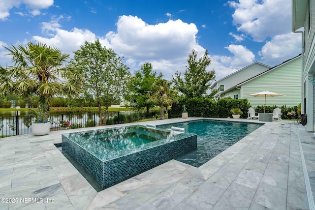 view of pool featuring a patio, fence, a pool with connected hot tub, and a water view