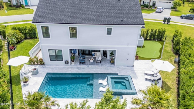 back of house featuring a putting green, a patio area, roof with shingles, a pool with connected hot tub, and an outdoor living space