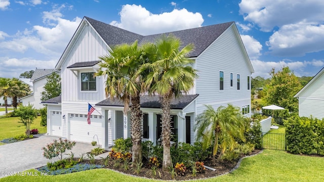 view of front of house featuring board and batten siding, a shingled roof, driveway, and an attached garage