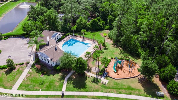aerial view of a pool, a large body of water, and a community park