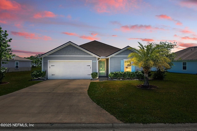 single story home featuring an attached garage, driveway, and a yard