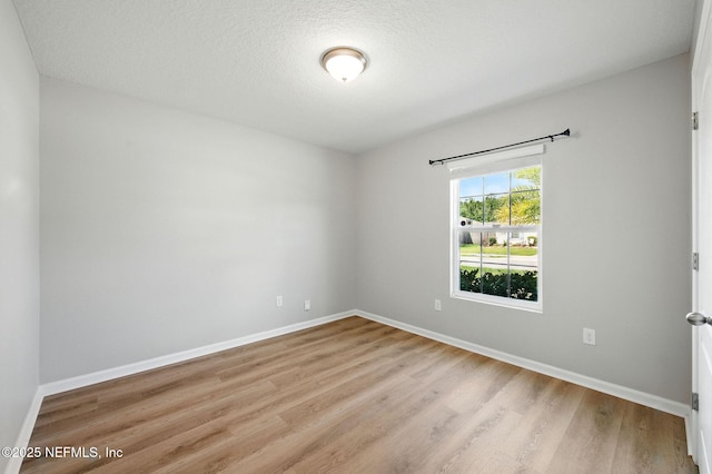 spare room featuring wood finished floors and baseboards