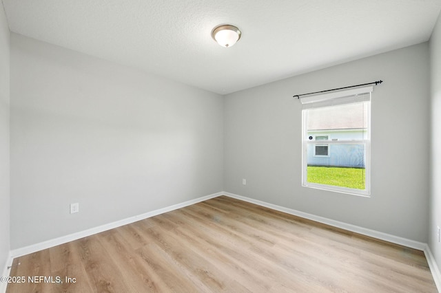 unfurnished room with wood finished floors and baseboards