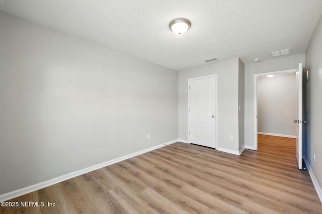 unfurnished bedroom featuring light wood-type flooring and baseboards