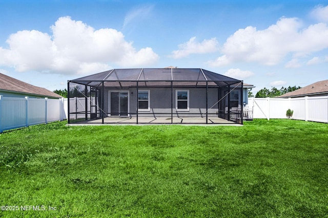 rear view of property featuring a patio and glass enclosure
