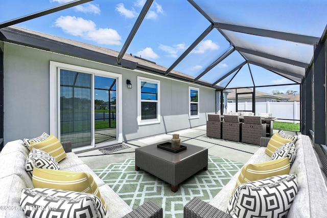 view of patio featuring outdoor lounge area, outdoor dining space, and glass enclosure