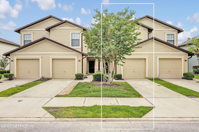 view of front of property featuring stucco siding, driveway, and a garage