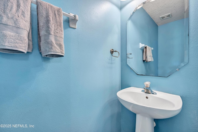 bathroom with a sink and a textured ceiling