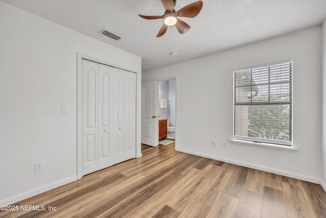 unfurnished bedroom featuring light wood finished floors, baseboards, a closet, a textured ceiling, and a ceiling fan