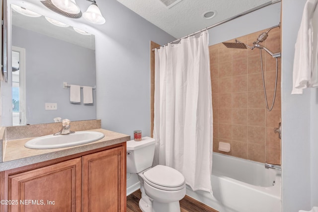full bathroom featuring toilet, shower / tub combo, wood finished floors, vanity, and a textured ceiling