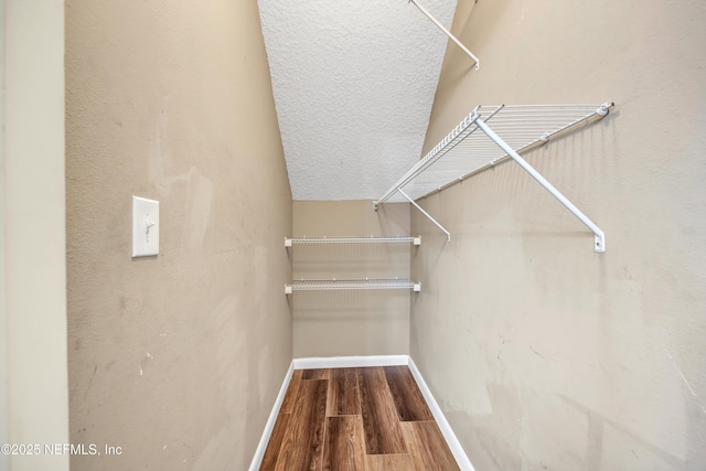 walk in closet with wood finished floors