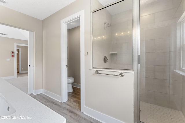 1339 Date St, Fernandina Beach, FL 32034 - bathroom featuring a stall shower, toilet, wood finished floors, and baseboards