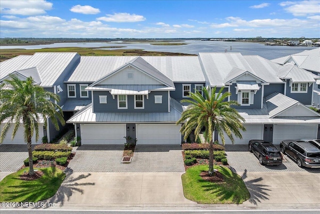 2540 Beach Blvd, Jacksonville Beach, FL 32250 - view of front of home with decorative driveway, an attached garage, metal roof, and a water view