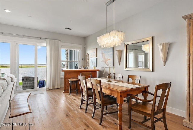 2540 Beach Blvd, Jacksonville Beach, FL 32250 - dining area featuring light wood-type flooring, baseboards, a water view, a chandelier, and recessed lighting