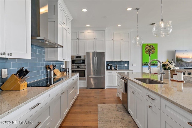 2540 Beach Blvd, Jacksonville Beach, FL 32250 - kitchen with stainless steel appliances, wall chimney exhaust hood, a sink, white cabinets, and recessed lighting