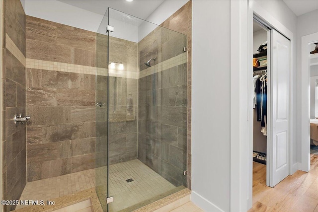 2540 Beach Blvd, Jacksonville Beach, FL 32250 - bathroom featuring a stall shower, a spacious closet, baseboards, and wood finished floors