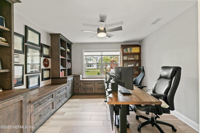 office area with a ceiling fan and light wood-type flooring
