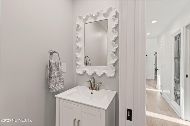 bathroom featuring recessed lighting, vanity, and wood finished floors