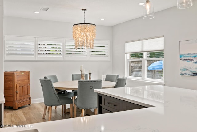 dining space with a chandelier, light wood-style flooring, recessed lighting, and baseboards