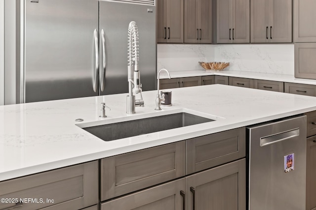kitchen featuring stainless steel appliances, gray cabinetry, and a sink