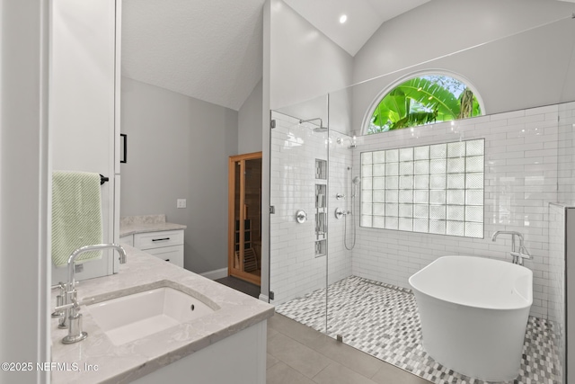 bathroom with lofted ceiling, a shower stall, double vanity, a freestanding tub, and tile patterned flooring