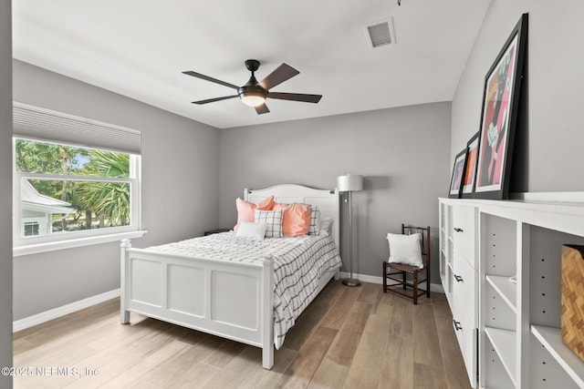 bedroom with light wood finished floors, baseboards, and a ceiling fan