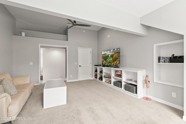 living area featuring a ceiling fan, carpet floors, baseboards, and vaulted ceiling