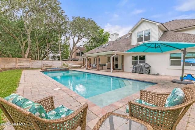 view of swimming pool with a patio, an outdoor living space, a fenced backyard, area for grilling, and a pool with connected hot tub
