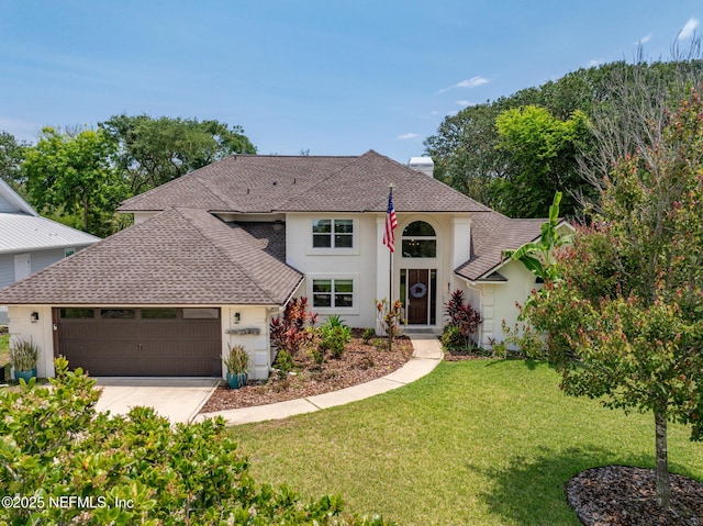 traditional-style house featuring a shingled roof, stucco siding, a front yard, a garage, and driveway
