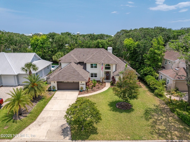 view of front of house with concrete driveway, an attached garage, a chimney, a front lawn, and a shingled roof